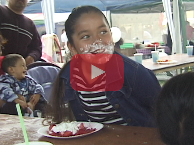 Play button showing young girl pie eating contestant with whipped cream on her face