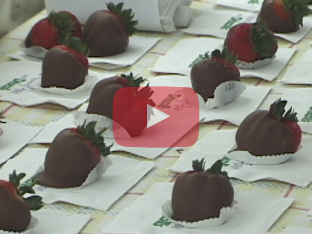 Play button showing chocolate covered strawberries